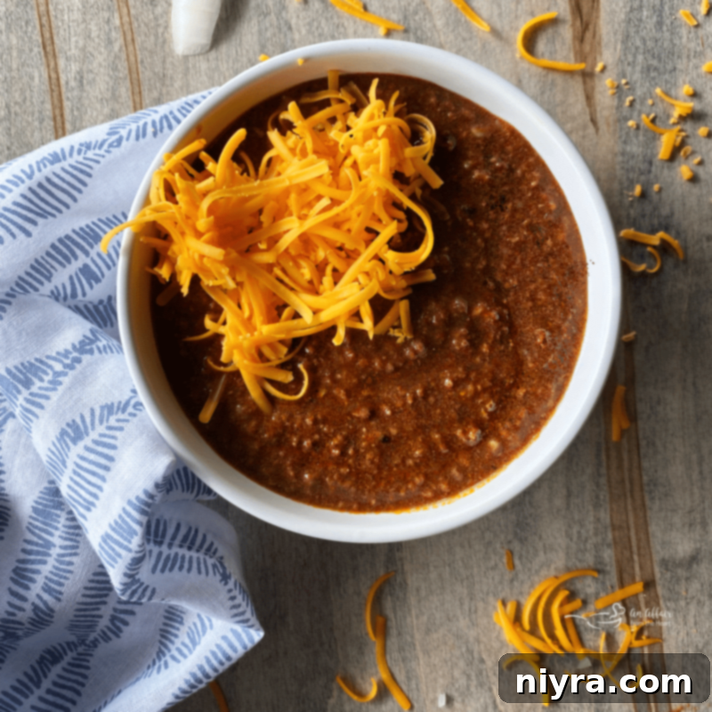 bowl of chili with cheese on top, ready to be served