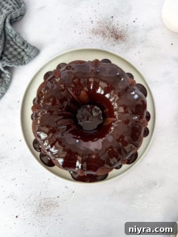 The rich, glossy chocolate coffee ganache being drizzled over the perfectly cooled Chocolate Espresso Bundt Cake.