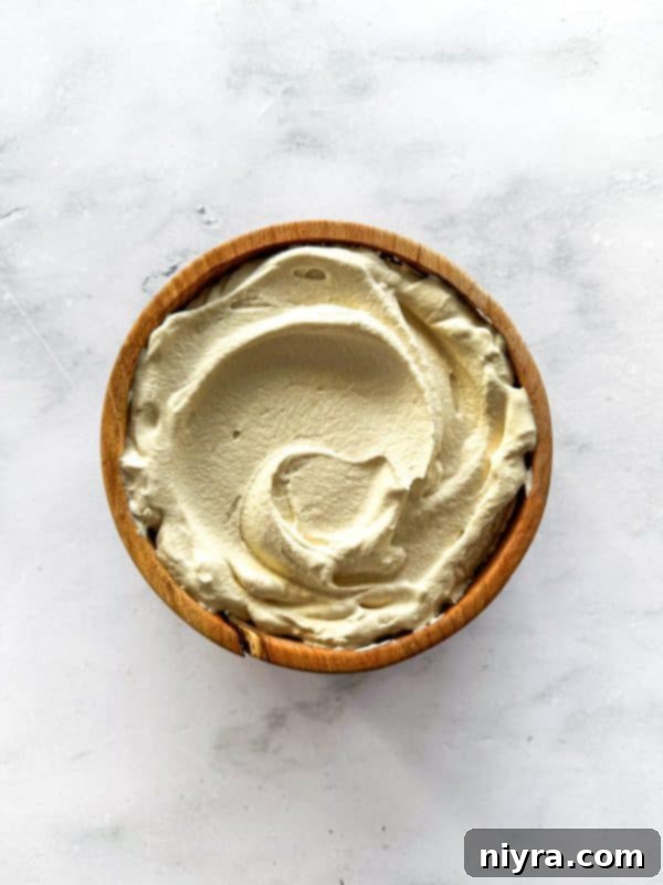 Freshly whipped coffee-infused cream, light and airy, ready to be piped onto the chocolate espresso cake.