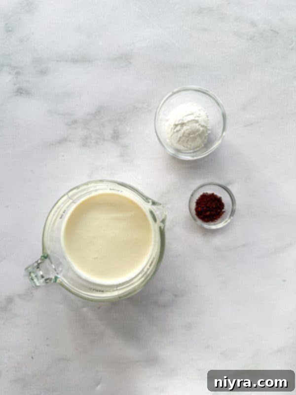 Freshly whipped heavy cream in a bowl, sweetened with powdered sugar and infused with instant coffee, ready to top the cake.