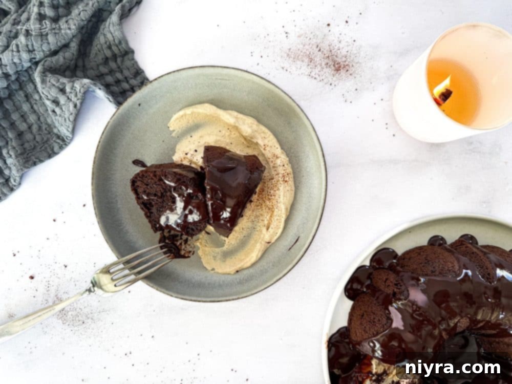 A stunning close-up of a slice of Chocolate Espresso Bundt Cake, revealing its moist texture, ganache, and whipped cream.