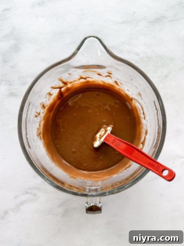 The Bundt cake batter poured perfectly into a greased bundt pan, ready for baking to achieve its elegant shape.