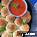 Italian Cheesy Bites 17 Italian Cheese Bombs in a cast iron skillet with marinara sauce