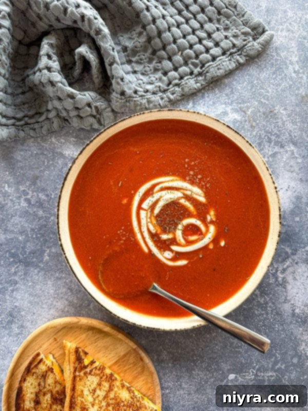 Close-up of fresh ingredients for fire roasted tomato soup on a cutting board.