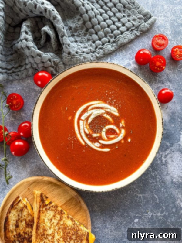 A large pot of fire roasted tomato soup simmering on a stove.