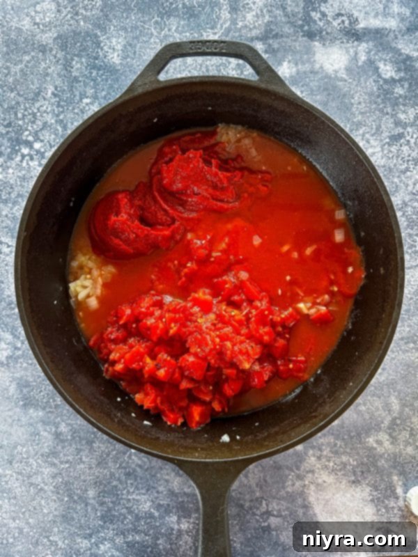 Step two: Adding canned tomatoes, paste, sauce, and chicken stock to the pot.