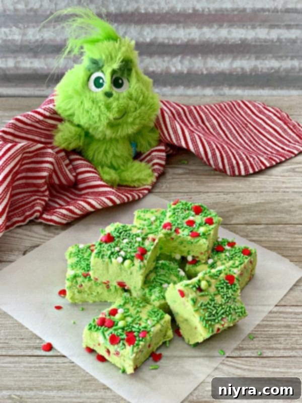 Grinch Fudge stacked on a napkin with a stuffed grinch toy in the background