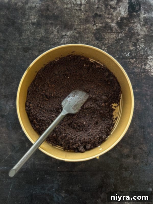 Decadent White Chocolate Raspberry Truffle Cheesecake 12 Pressing crushed Oreos and butter into a springform pan for the crust