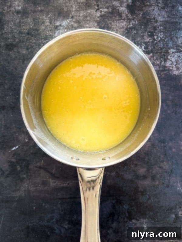 Decadent White Chocolate Raspberry Truffle Cheesecake 13 Heating half and half with white chocolate pieces in a saucepan