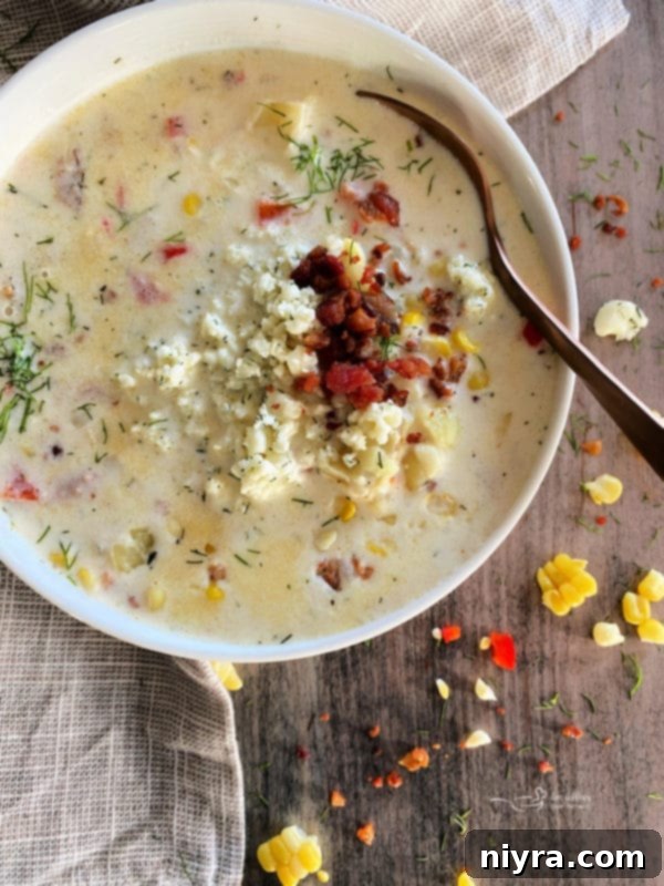 Cheesy Potato Corn Chowder served in a rustic bowl with a spoon