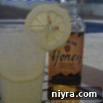 Bourbon Lemonade in a tall glass, garnished with lemon slices