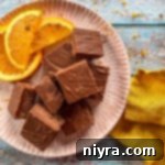 A plate of orange fudge squares, glistening and inviting, ready to be enjoyed as a delightful sweet treat.