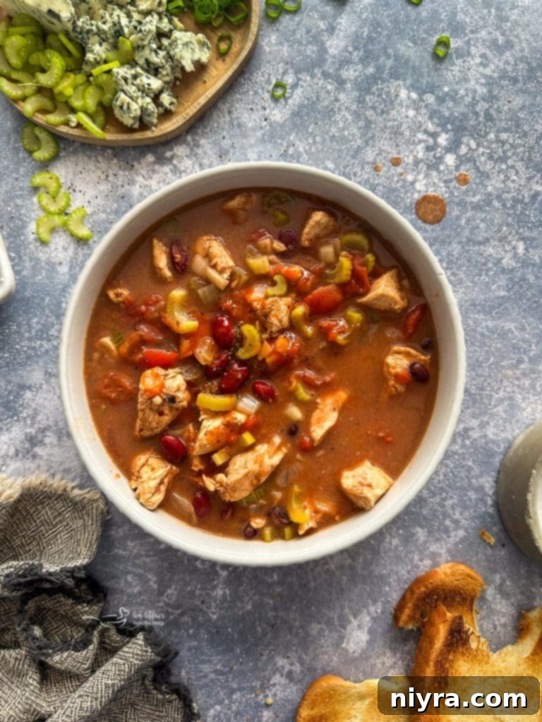 A serving of Buffalo Chicken Chili garnished with fresh herbs and a side of crusty bread, ready to be enjoyed.