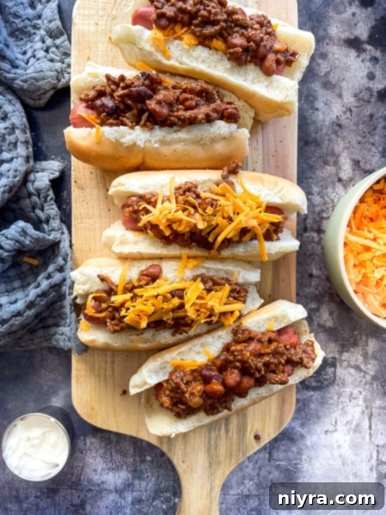 Close up of a chili cheese dog with generous cheese topping.