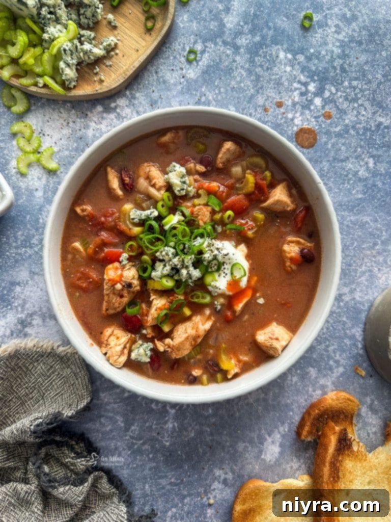 Buffalo Chicken Chili simmering and ready in a slow cooker, ready to be served.