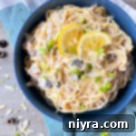 one bowl filled with pasta, tuna, mushrooms, olives, and lemon