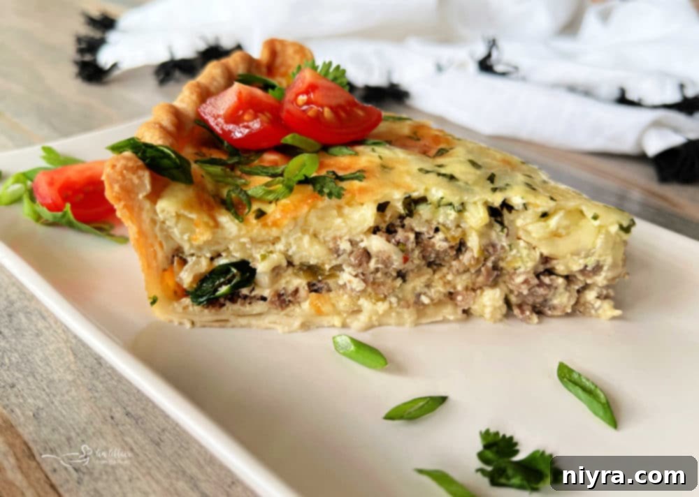 A slice of Green Chile Quiche with Sausage on a plate, showing the flaky crust and rich filling with green chiles.