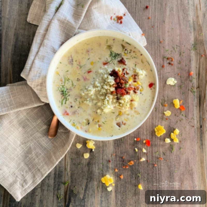 Cheesy Potato Corn Chowder in a white bowl with a tan napkin
