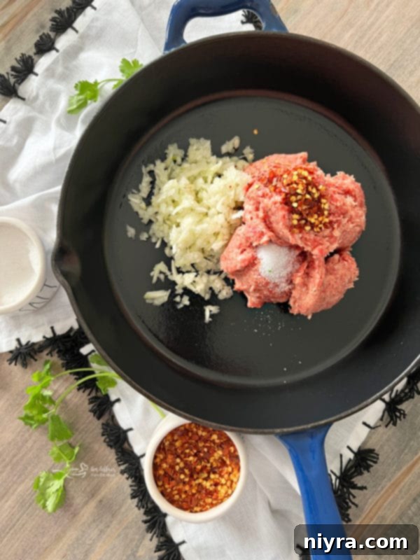 Raw ingredients for Green Chile Quiche: a bowl of eggs and half & half, and cooked sausage with onions and green chiles.