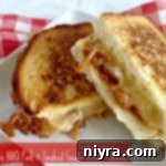 Close up of a gourmet grilled cheese sandwich filled with apple BBQ pork and melted smoked gouda