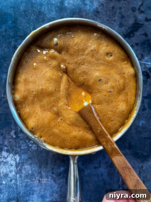 Irresistible Candy Coated Crispix Treat 11 Caramel mixture boiling in a saucepan on the stove