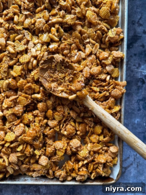 Irresistible Candy Coated Crispix Treat 13 Caramel being poured over Crispix cereal and peanuts in a bowl
