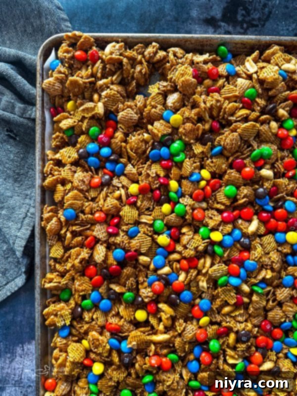 Irresistible Candy Coated Crispix Treat 14 Coated Crispix Mix spread on a baking sheet, ready for the oven