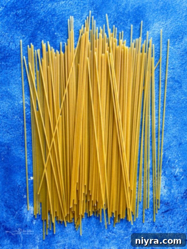 A close-up shot of uncooked spaghetti noodles, neatly bundled, waiting to be transformed into a delicious Italian dish.