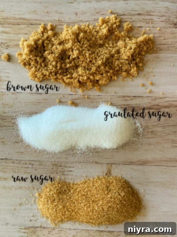 A hand scooping natural sugar scrub from a jar.