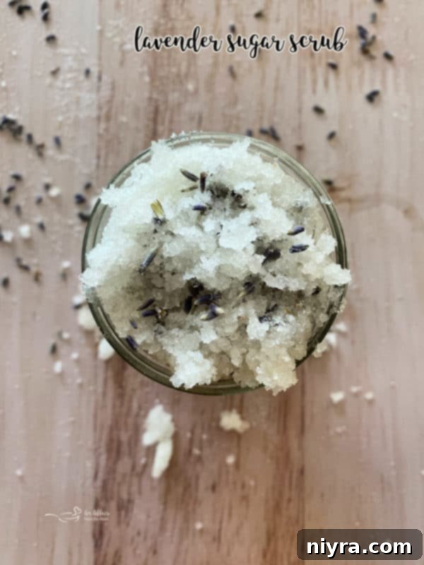 Lavender sugar scrub jar adorned with a ribbon and dried lavender.
