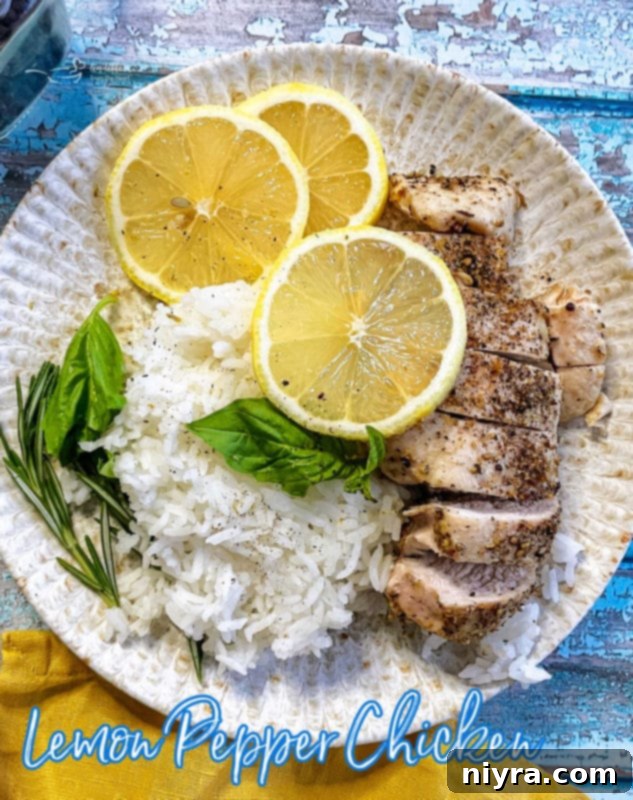 Hero shot of a perfectly baked lemon pepper chicken breast with fresh lemons.