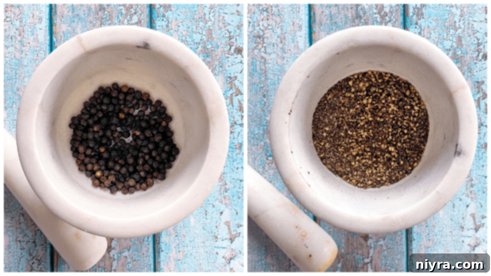 A hand grinding black peppercorns, preparing homemade lemon pepper seasoning.