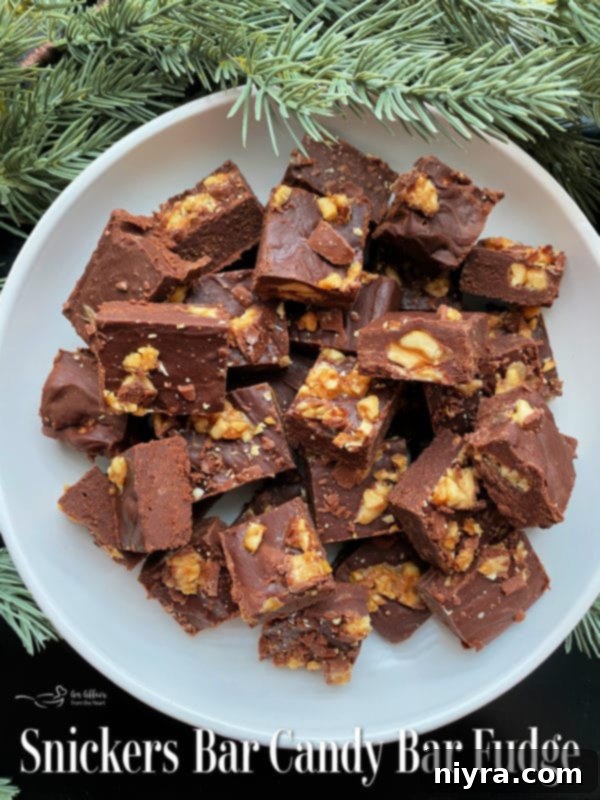 Snickers Candy Bar Fudge squares on a rustic wooden board