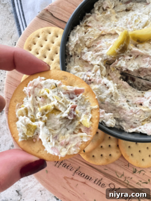 Dilled Brussels Sprouts Dip in a white bowl with fresh dill garnish