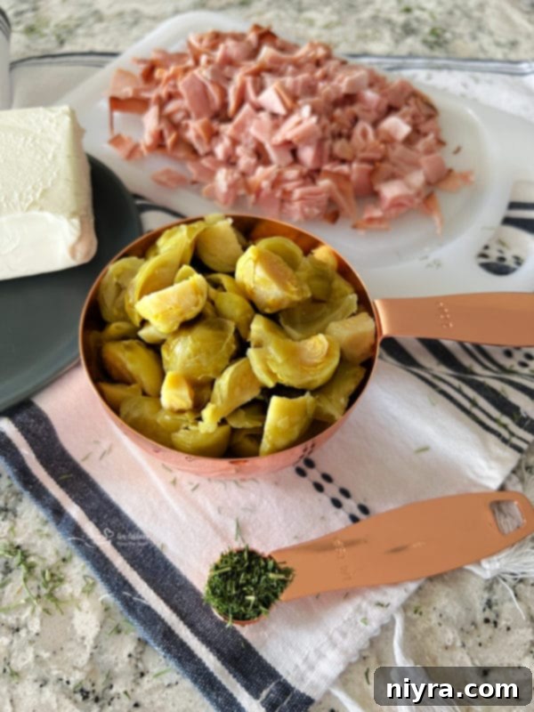 Cream cheese being mixed with fresh dill for Brussels sprouts dip
