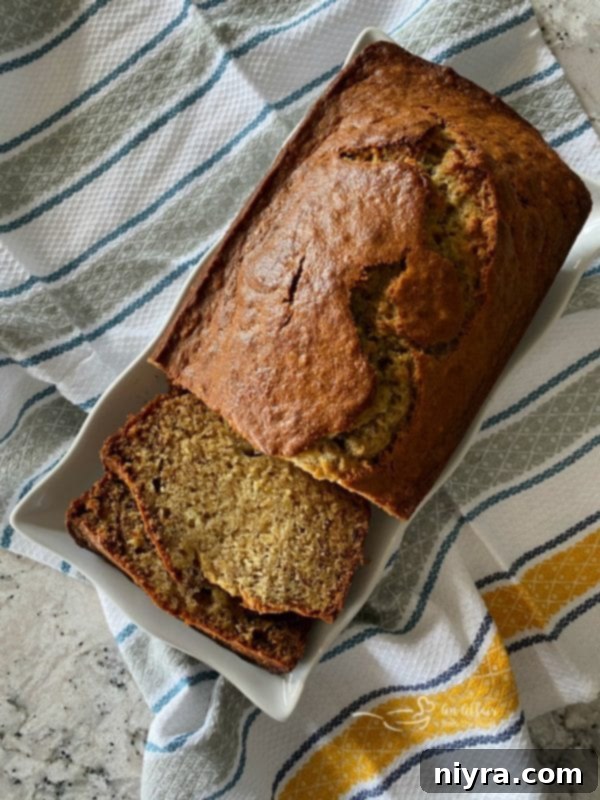 Unforgettable Banana Bread 8 Perfectly baked banana bread loaf on a serving plate.