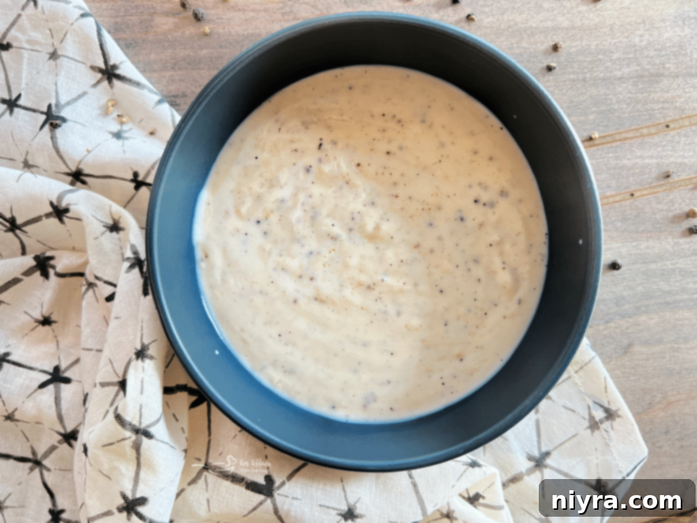 Classic Southern White Gravy 3 A bowl of creamy white country gravy with black pepper