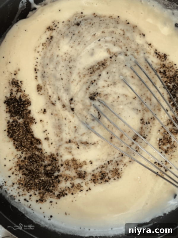 Classic Southern White Gravy 10 Whisking in salt and pepper into the gravy