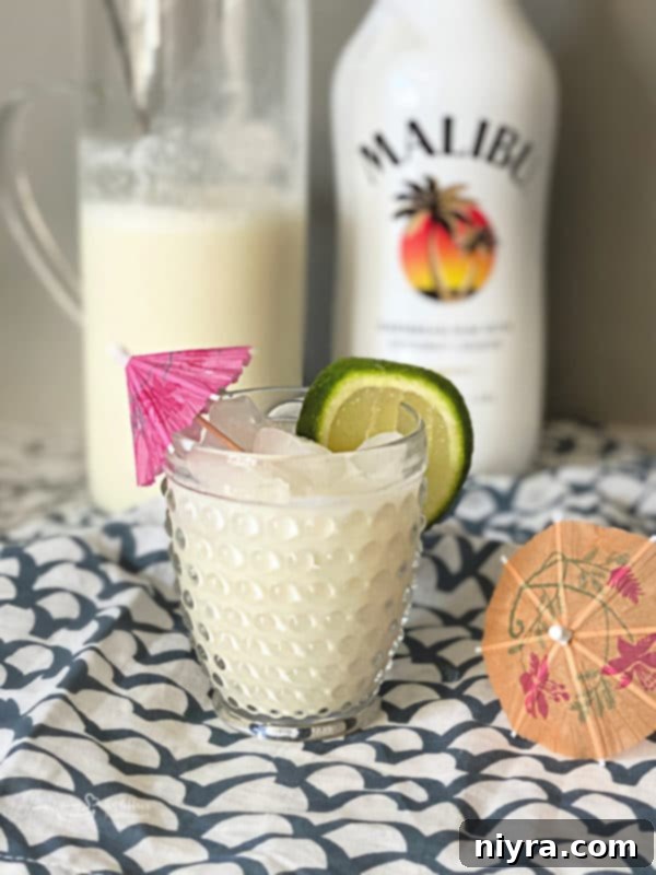 Finished Brazilian Lemonade Cocktail with lime and umbrella