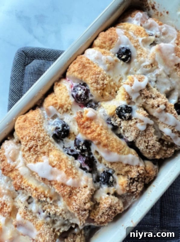 Close-up of a slice of warm Blueberry Lemon Pull-Apart Bread with streusel and lemon glaze