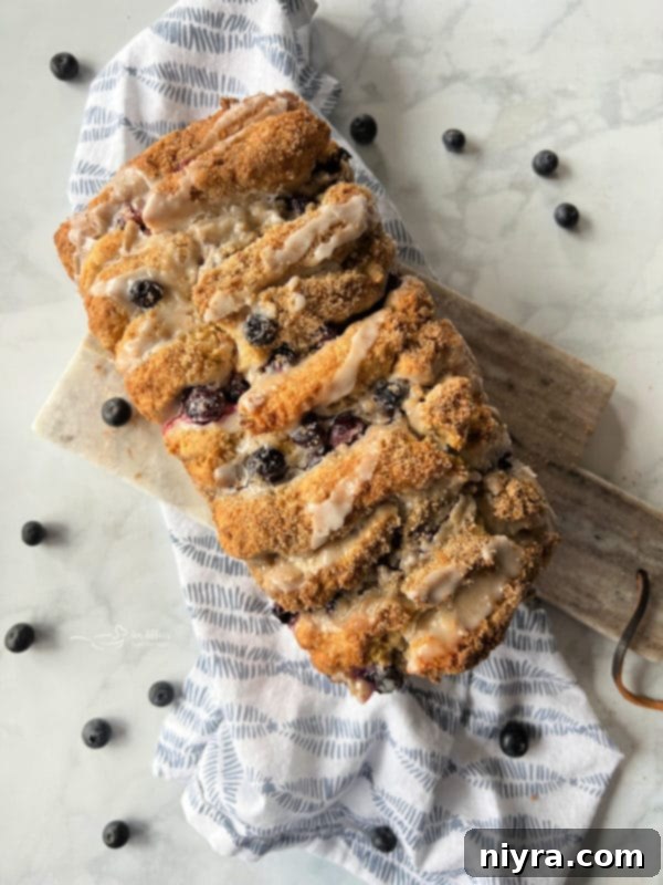Top-down view of a golden-brown Blueberry Loaf with visible streusel and blueberries