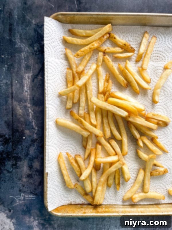 Deep-fry french fries in 350F oil until golden brown. Drain french fries on a paper towel-lined tray.