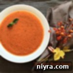 Overhead of Tomato Basil Soup in a white bowl with text "Tomato Basil Soup"