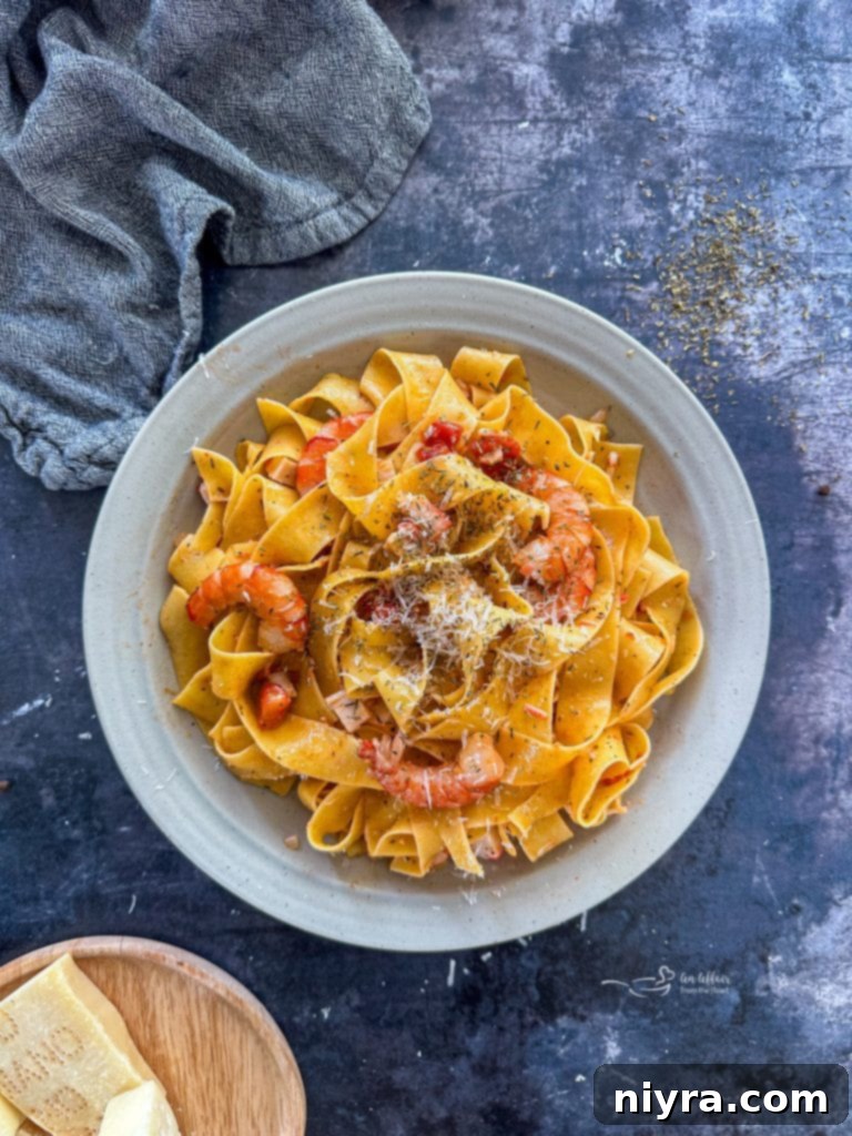Overhead shot of Shrimp and Crab Pasta in a large serving bowl, garnished with fresh herbs.