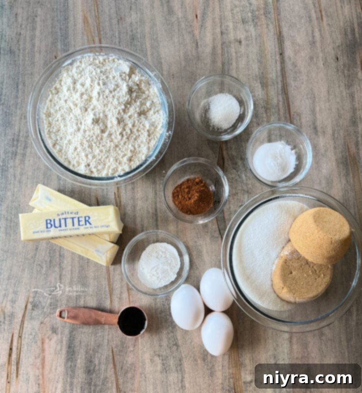 A flat lay image showing all the ingredients neatly arranged for making Cowboy Cookies, including flour, sugars, butter, eggs, chocolate chips, pecans, coconut, and Rice Krispies cereal.