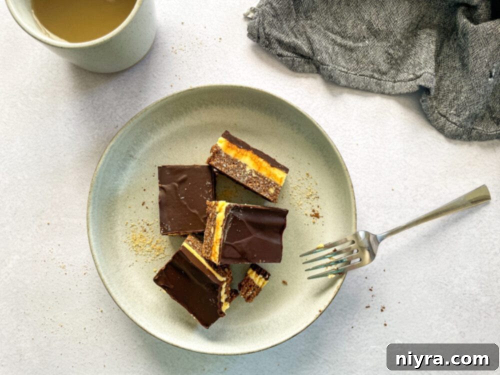 Nanaimo Bars displayed on a serving plate, highlighting their neat layers