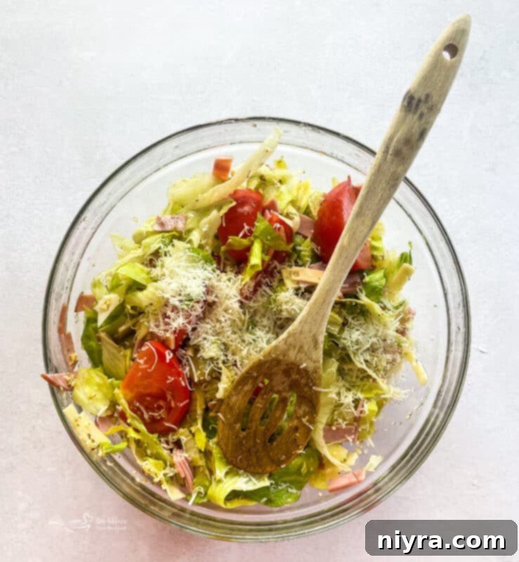 The 1905 Salad dressing poured over the salad ingredients, ready for tossing.