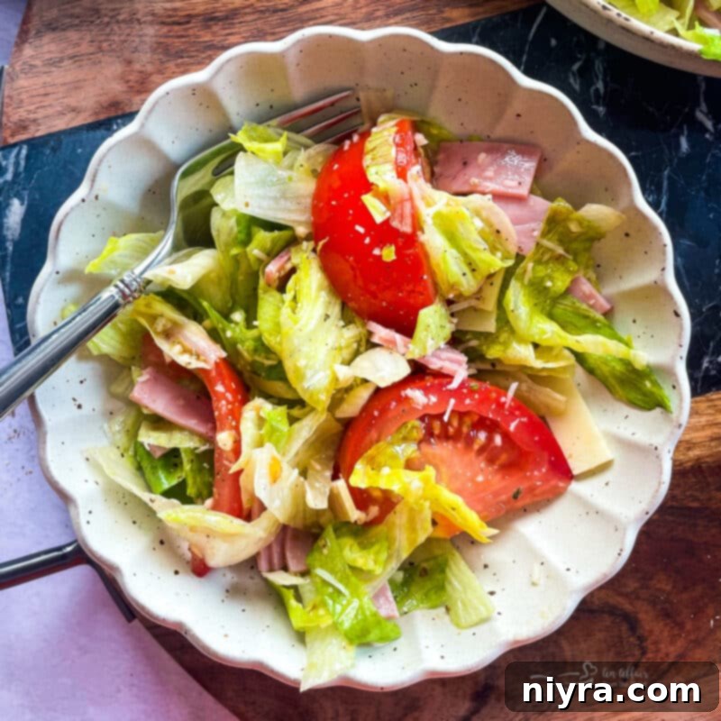 The finished Columbia 1905 Salad, topped with Romano cheese, served in a large white bowl.