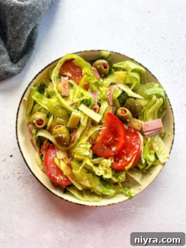 Close-up of the Columbia 1905 Salad, showing the shredded iceberg lettuce, julienned ham, Swiss cheese, and olives.