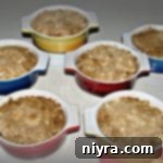 Six individual peach crisps arranged on a rustic table